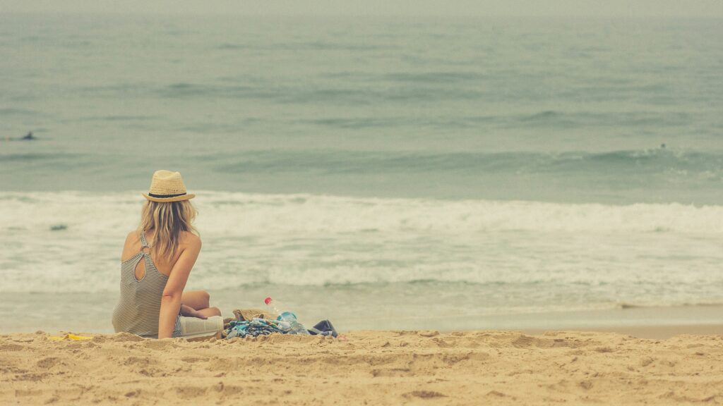 海辺でリラックスしながら海を眺める女性