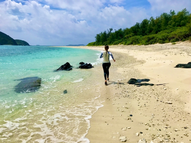 海辺を水着を着て走る女性